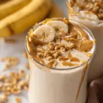 Healthy peanut butter banana smoothie with banana slices and chia seeds on top, perfect for breakfast or a post-workout snack.